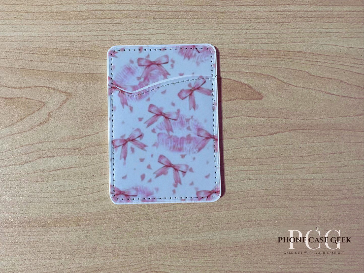 Custom adhesive phone wallet/card holder with pink bows design on a wooden surface.
