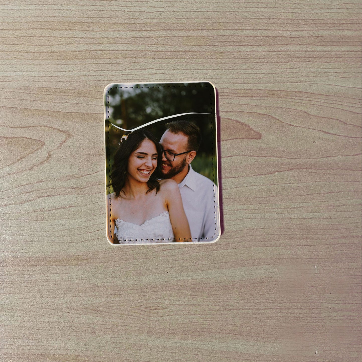 Custom phone card holder / wallet with a printed design of a couple on a wooden surface.