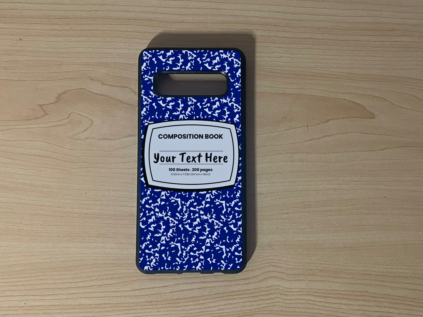 Custom phone case for the Samsung S10 and S10e with a blue and white composition notebook design with text "Your text here" on a wooden surface.