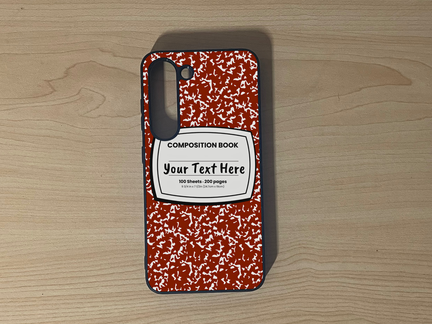 Custom phone case for the Samsung S23 and S23 Plus with a red and white composition notebook design with text "Your text here" on a wooden surface.