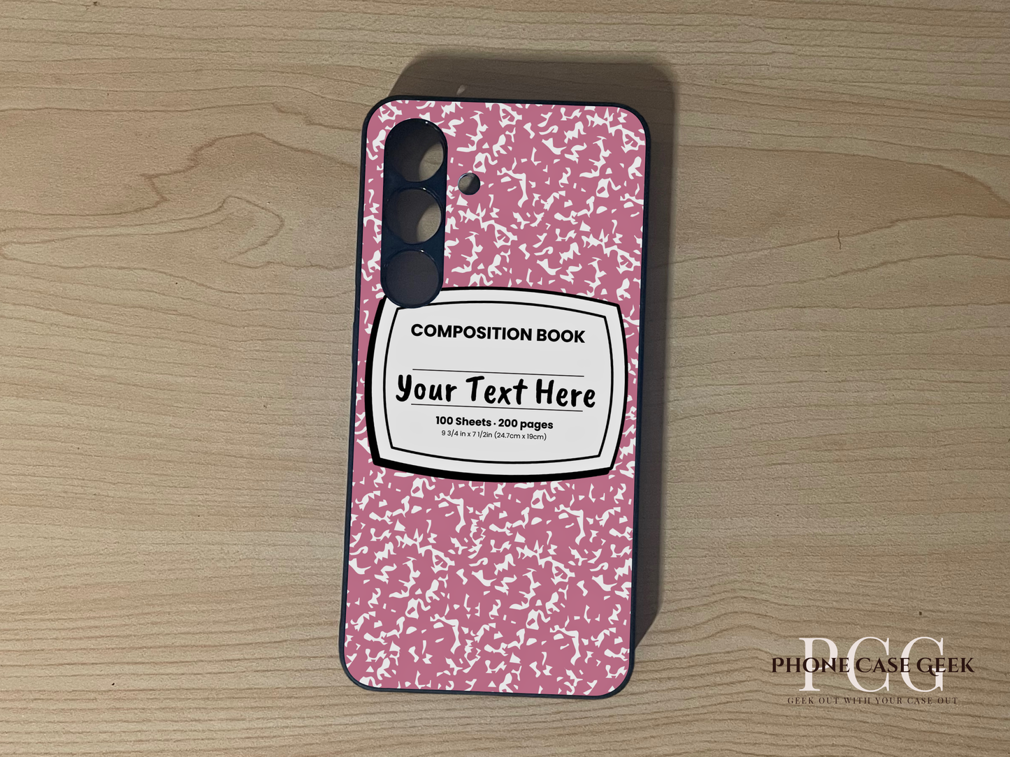 Custom phone case for the Samsung S24 and S24 Plus with a pink and white composition notebook design with text "Your text here" on a wooden surface.
