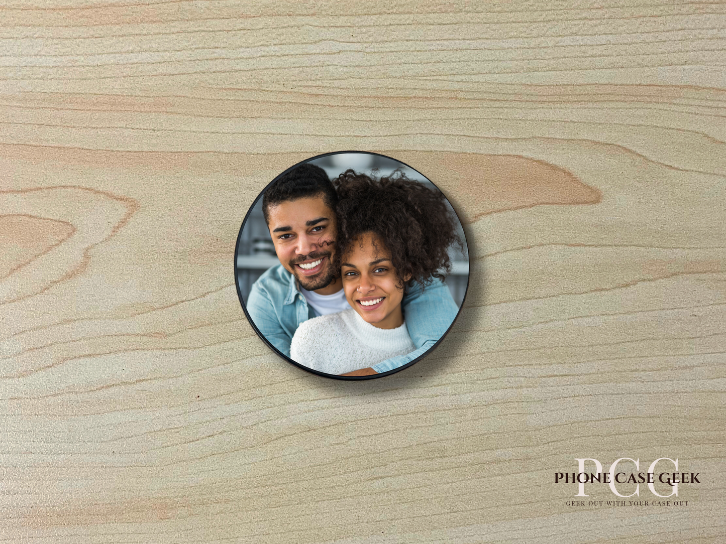 Custom adhesive phone grip with photo of a couple on a wooden surface.