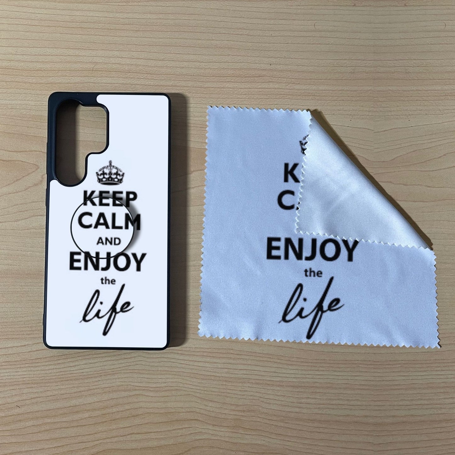 Custom Samsung case bundle set with matching phone grip and cleaning microfiber cloth with "Keep calm and enjoy the life" text design on a wooden surface