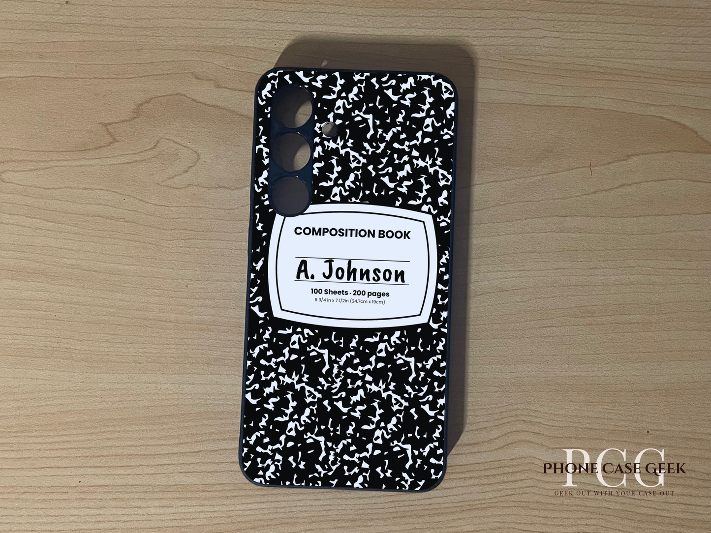 Custom Samsung S24 and S24 Plus case with black and white composition book design with "A. Johnson" written on a wooden surface