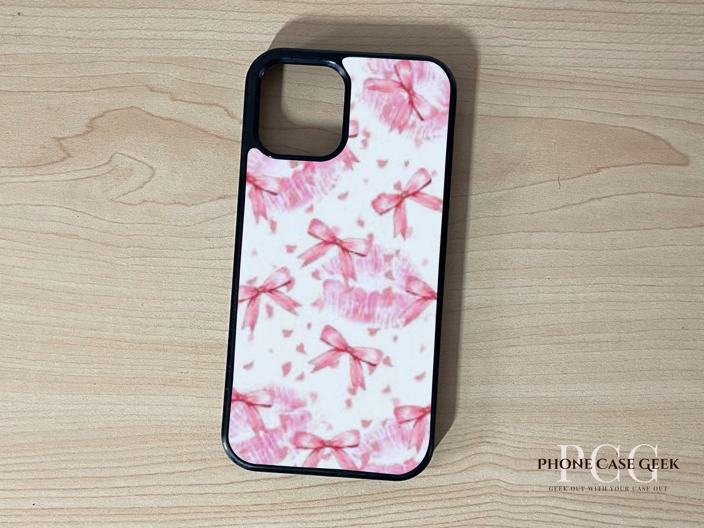 Custom iPhone case with pink bow pattern on a wooden surface.