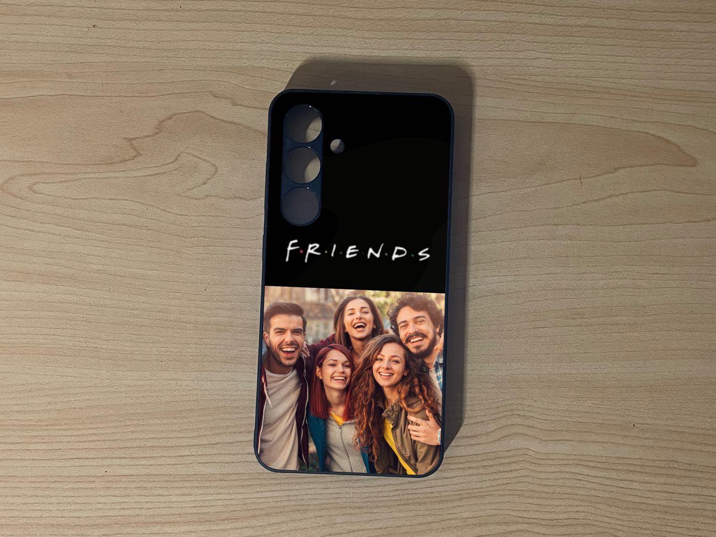 Custom phone case for the Samsung S24 and S24 Plus with 2 photo collage with 'Friends' text and a group photo on a wooden surface.
