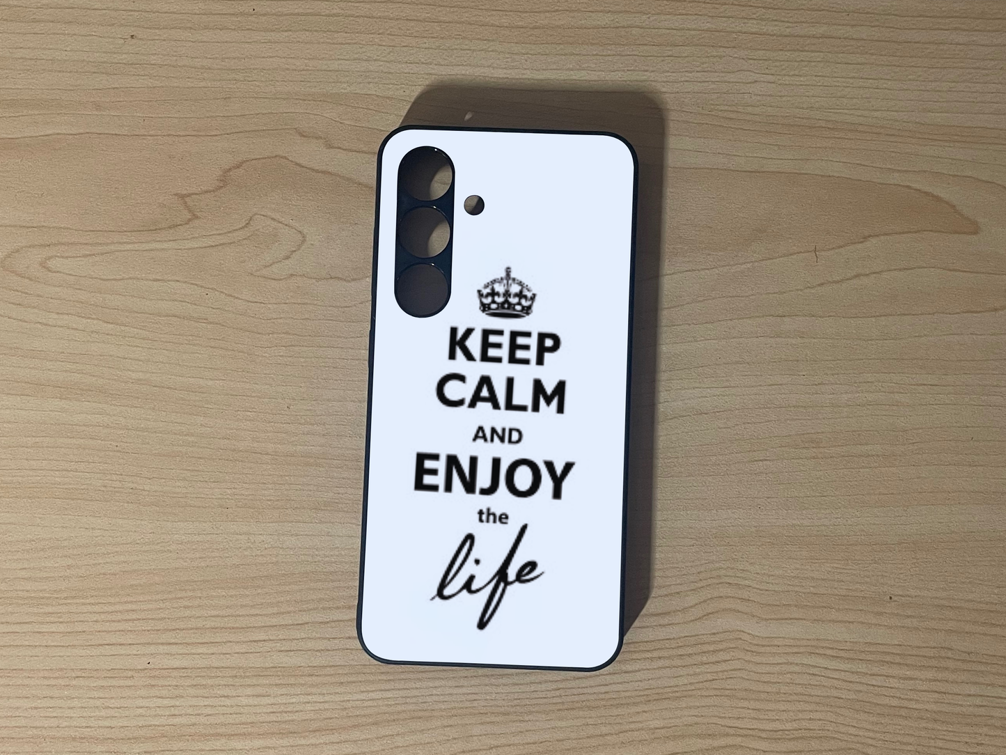 Custom phone case for Samsung S24 and S24 Plus with 'Keep Calm and Enjoy the Life' text design on a wooden surface