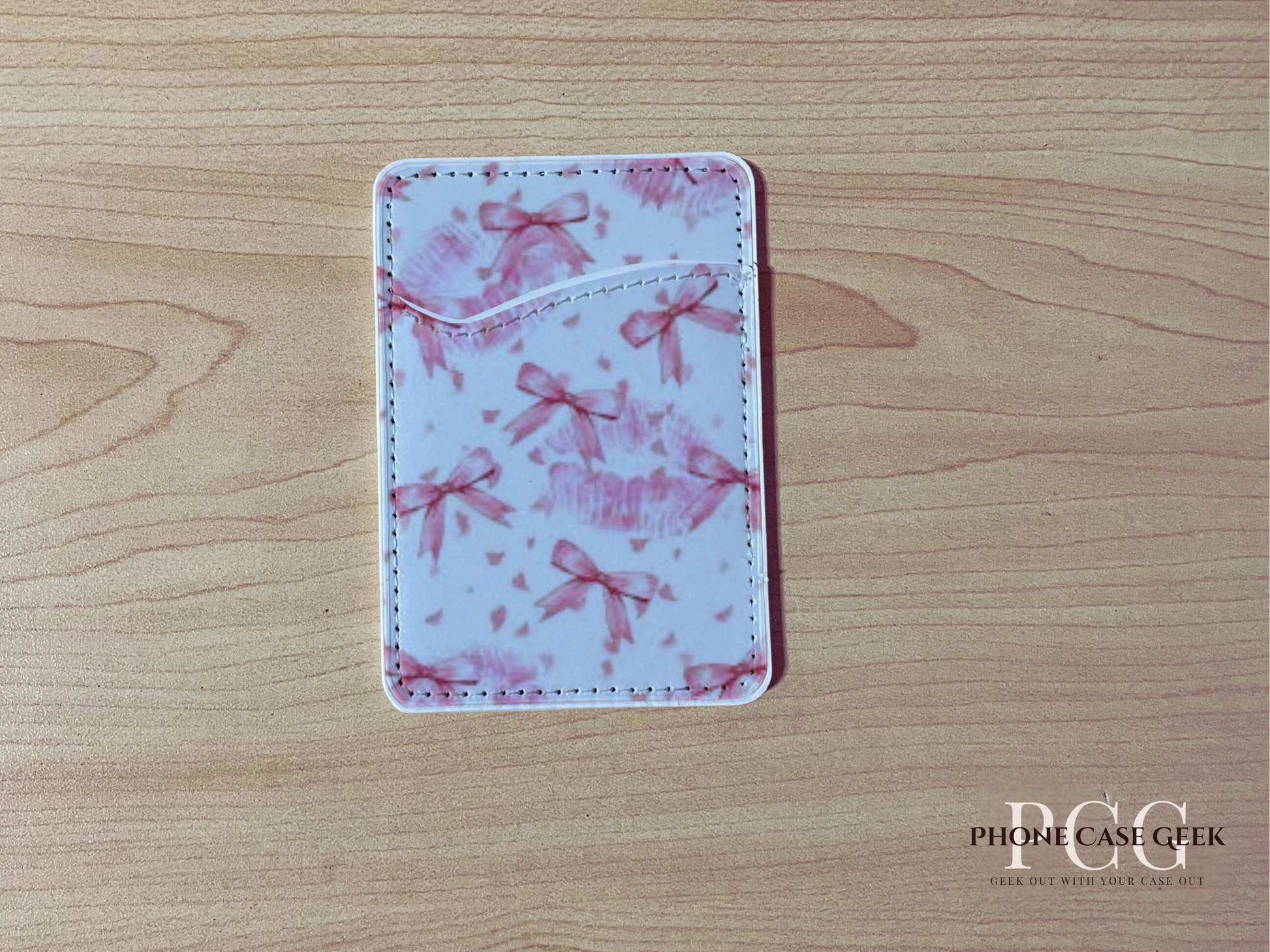 Custom adhesive phone wallet/card holder with pink bows design on a wooden surface.