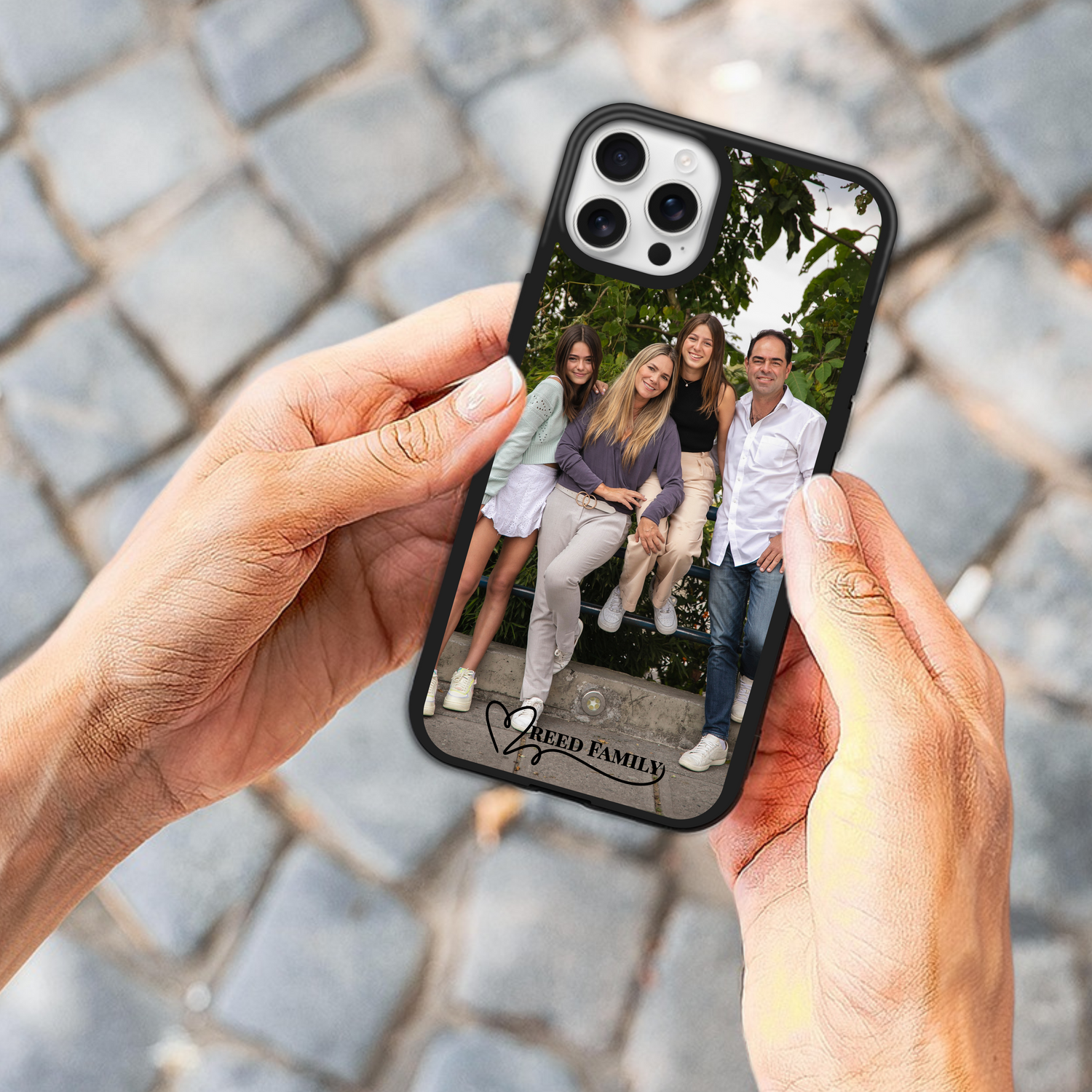 Custom phone case held by woman, featuring a family photo and personalized text that says "Reed Family" — perfect for showcasing cherished memories.