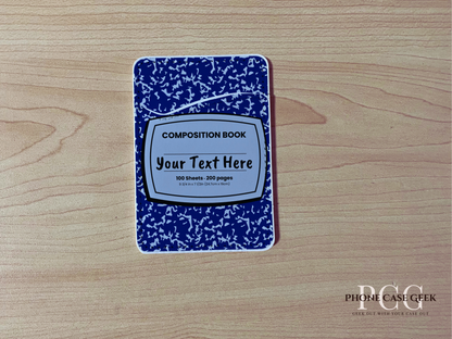 Custom adhesive phone wallet/card holder with blue and white composition notebook design on a wooden surface.