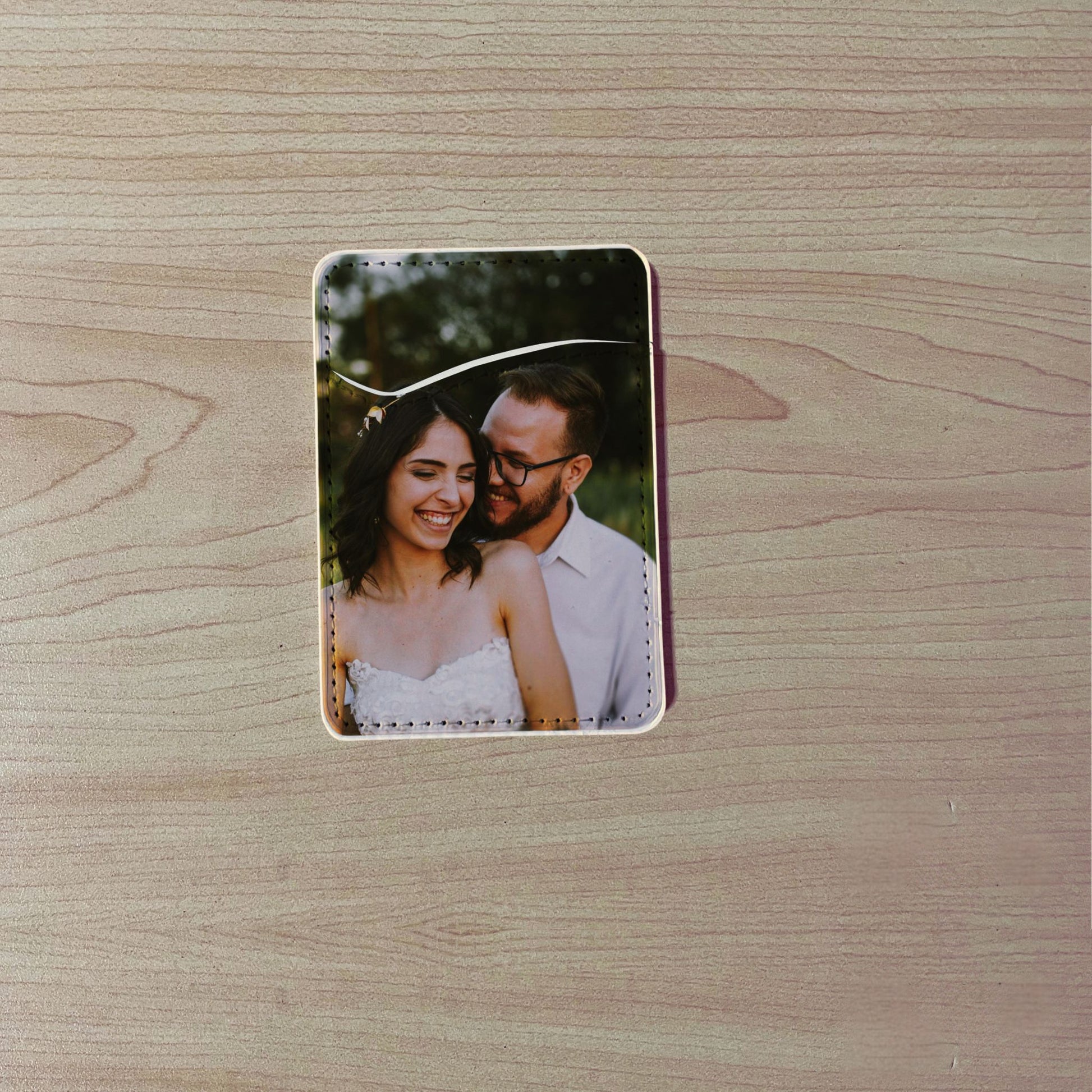 Custom phone card holder / wallet with a printed design of a couple on a wooden surface.