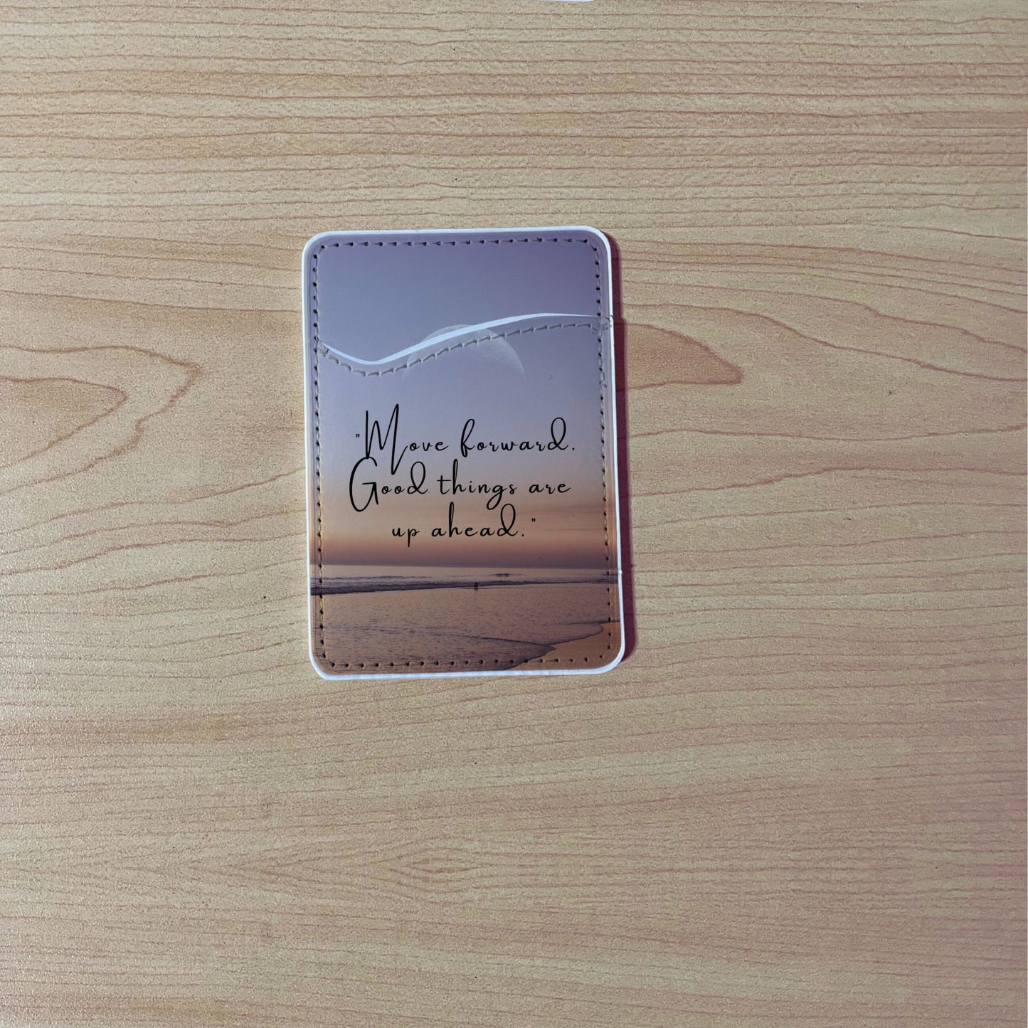 Custom phone wallet/card holder with beach image with quote design "Move forward good things are up ahead" text on a wooden surface.