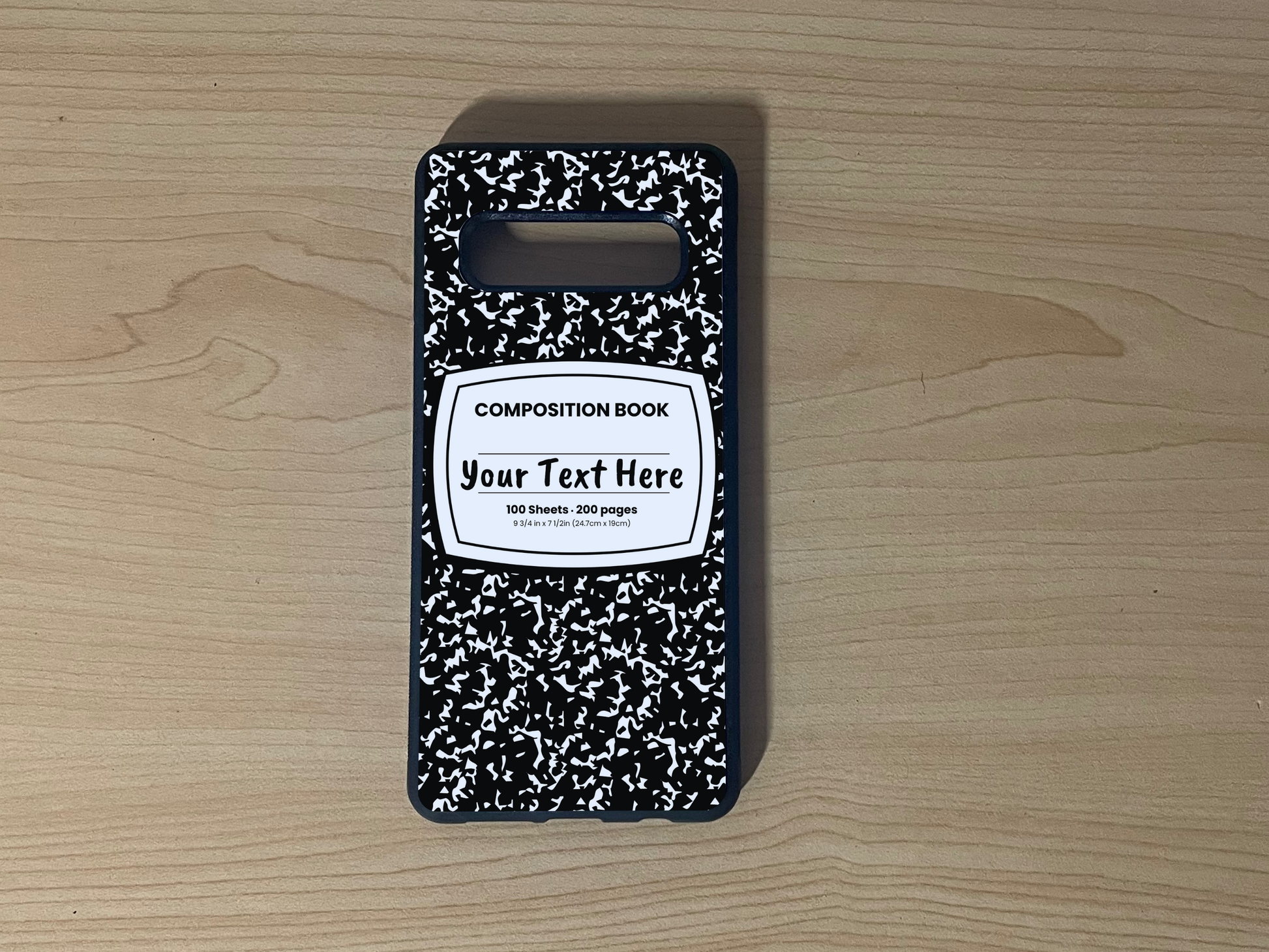 Custom phone case for the Samsung S10 and S10e with a black and white composition notebook design with text "Your text here" on a wooden surface.