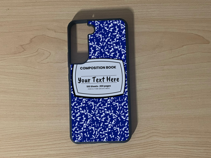 Custom phone case for the Samsung S21 and S21 Plus with a blue and white composition notebook design with text "Your text here" on a wooden surface.
