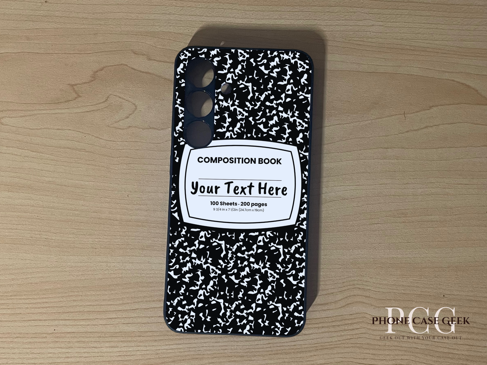 Custom phone case for the Samsung S24 and S24 Plus with a black and white composition notebook design with text "Your text here" on a wooden surface.