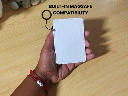 Hand holding a white phone card holder with showing the "BUILT-IN MAGSAFE COMPATIBILITY' text on a wooden surface.