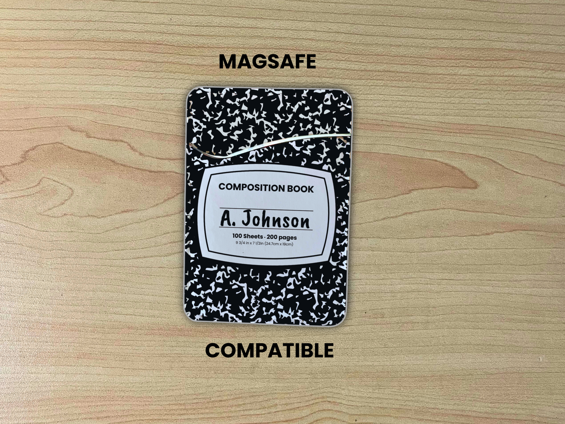 MagSafe compatible phone wallet/card holder with black and white composition notebook design with customizable text on a wood background.