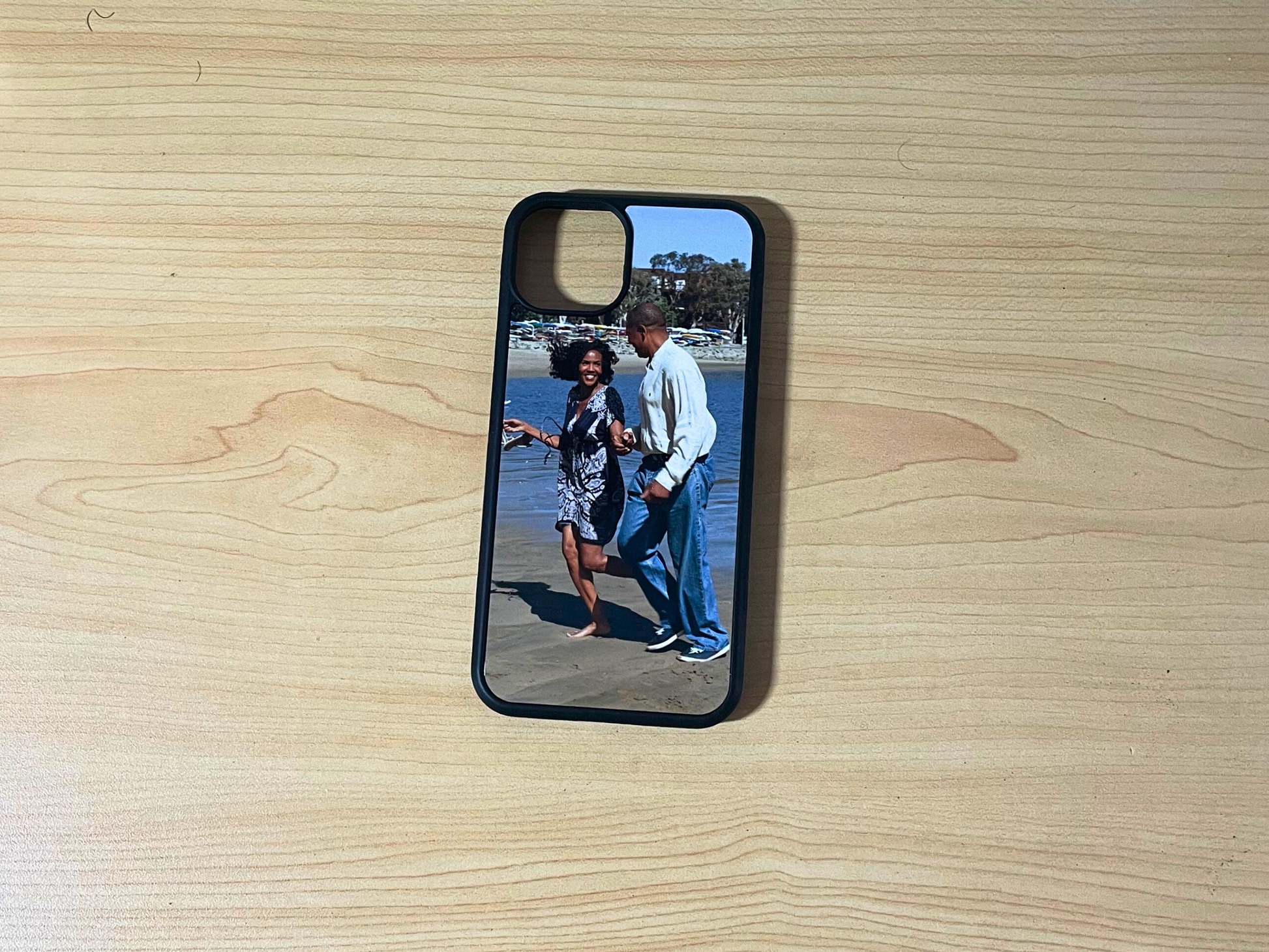 Phone case with a printed image of two people on a wooden surface