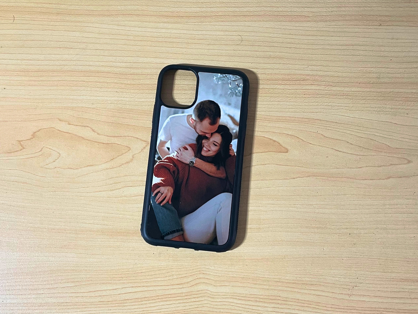 Phone case with a printed image of a couple on a wooden surface