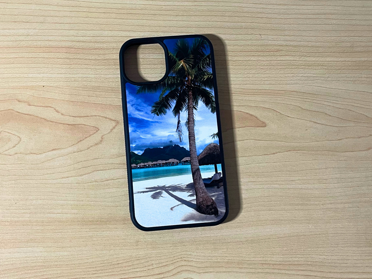 Phone case with tropical beach design on a wooden surface