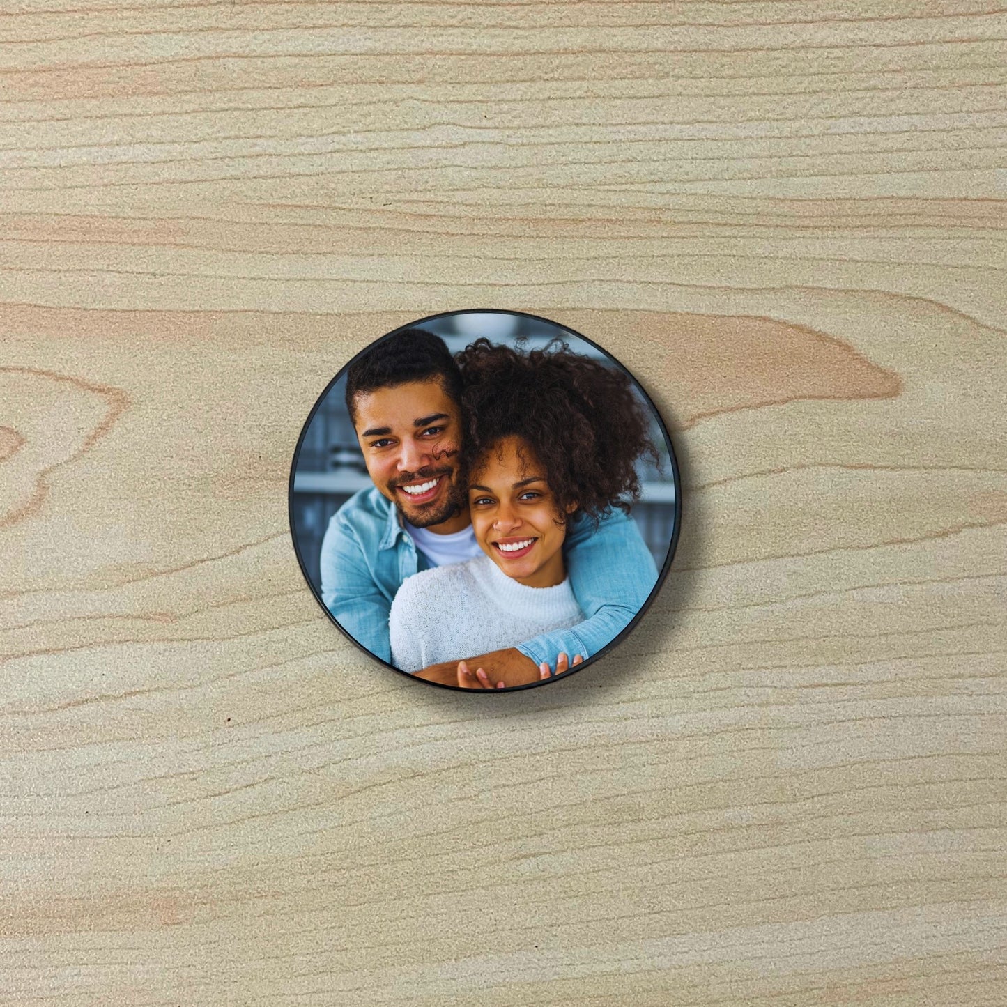 Custom adhesive phone grip with photo of a couple on a wooden surface.