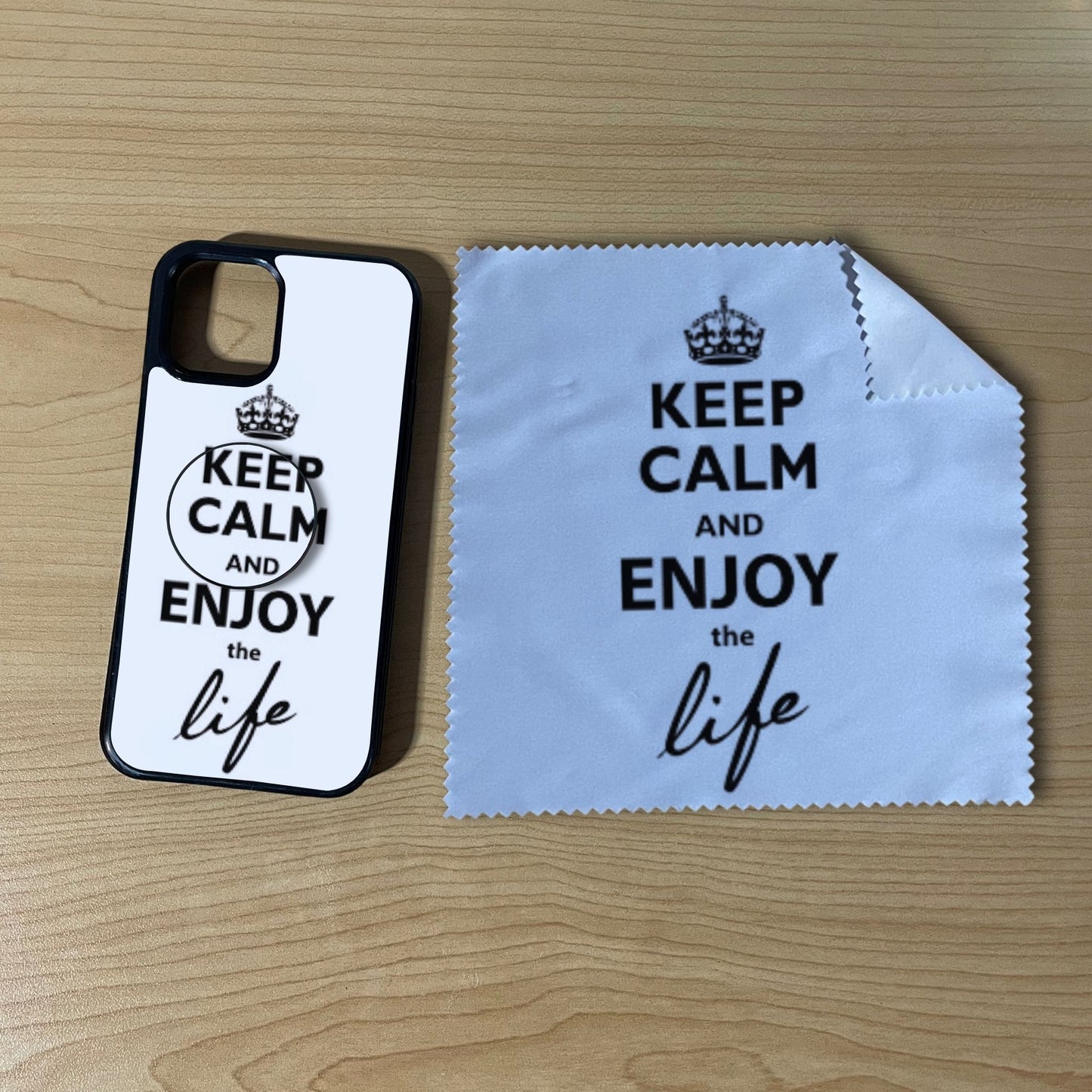 Custom iPhone case bundle set with matching phone grip and cleaning microfiber cloth with "Keep calm and enjoy the life" text design on a wooden surface