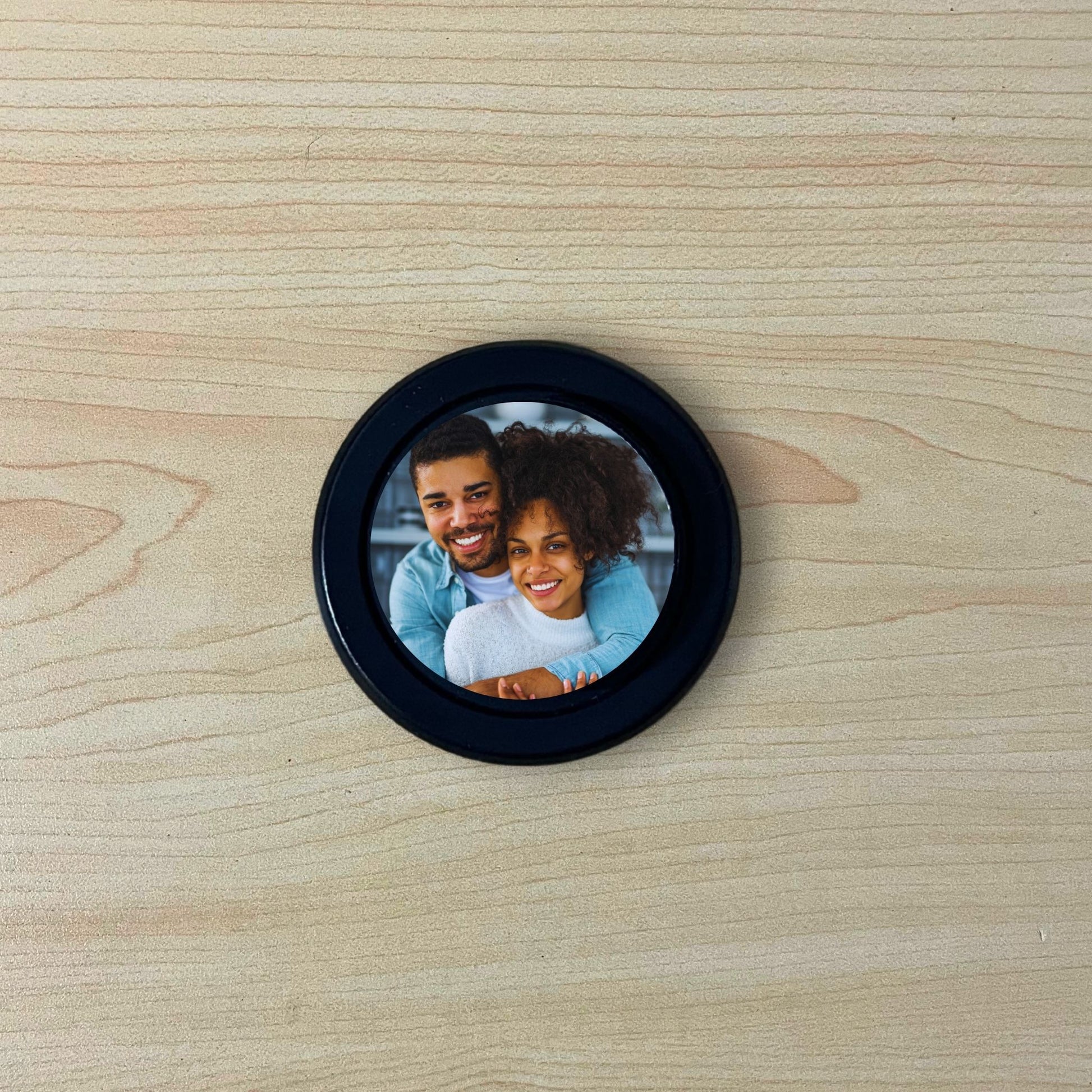 Custom black base Magsafe phone grip with photo of a couple on a wooden surface.