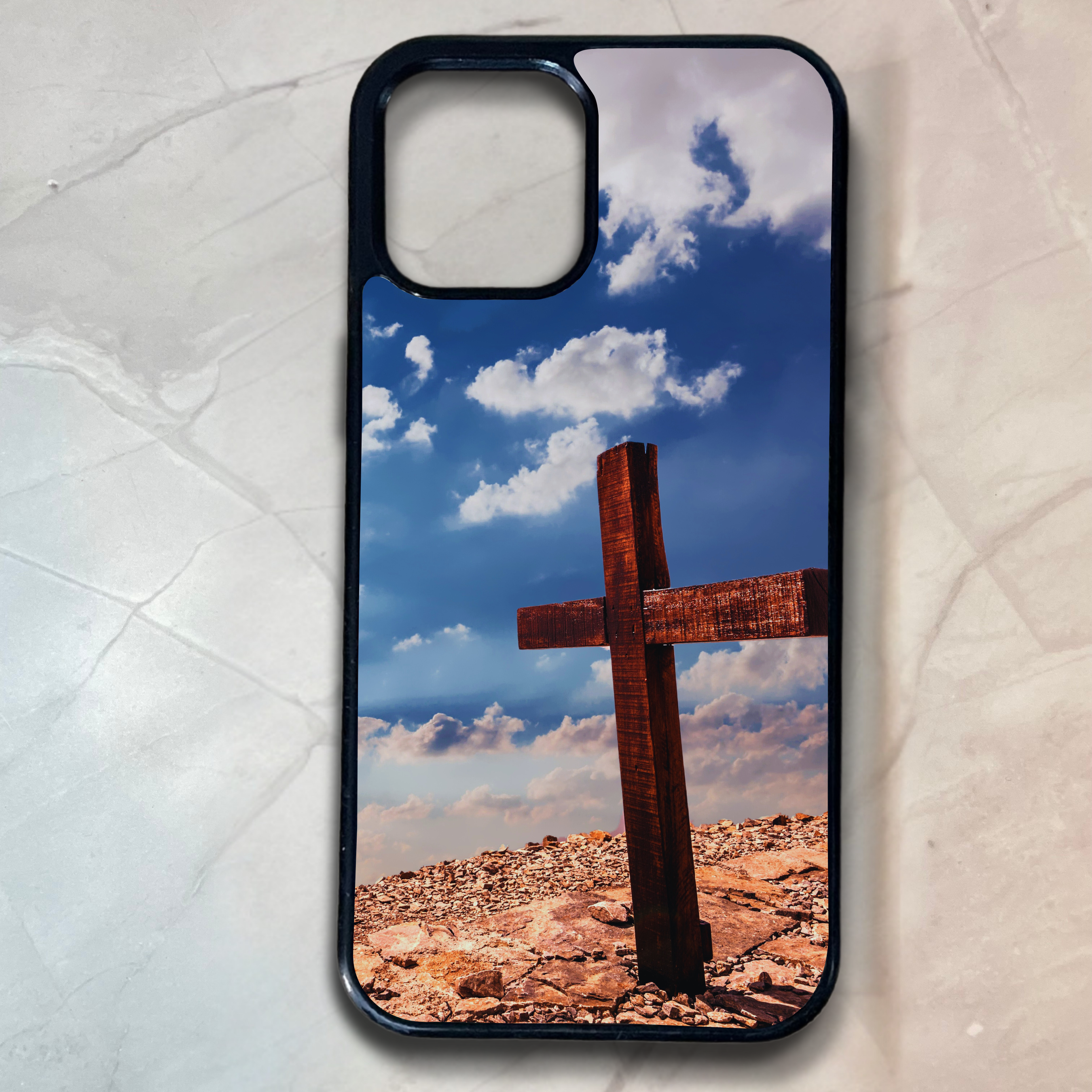 Phone case with a cross on a rocky landscape and blue sky