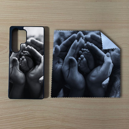 Custom Samsung case bundle set with hands holding a baby's foot design with matching phone grip and matching microfiber cloth phone screen cleaner on a wooden surface.