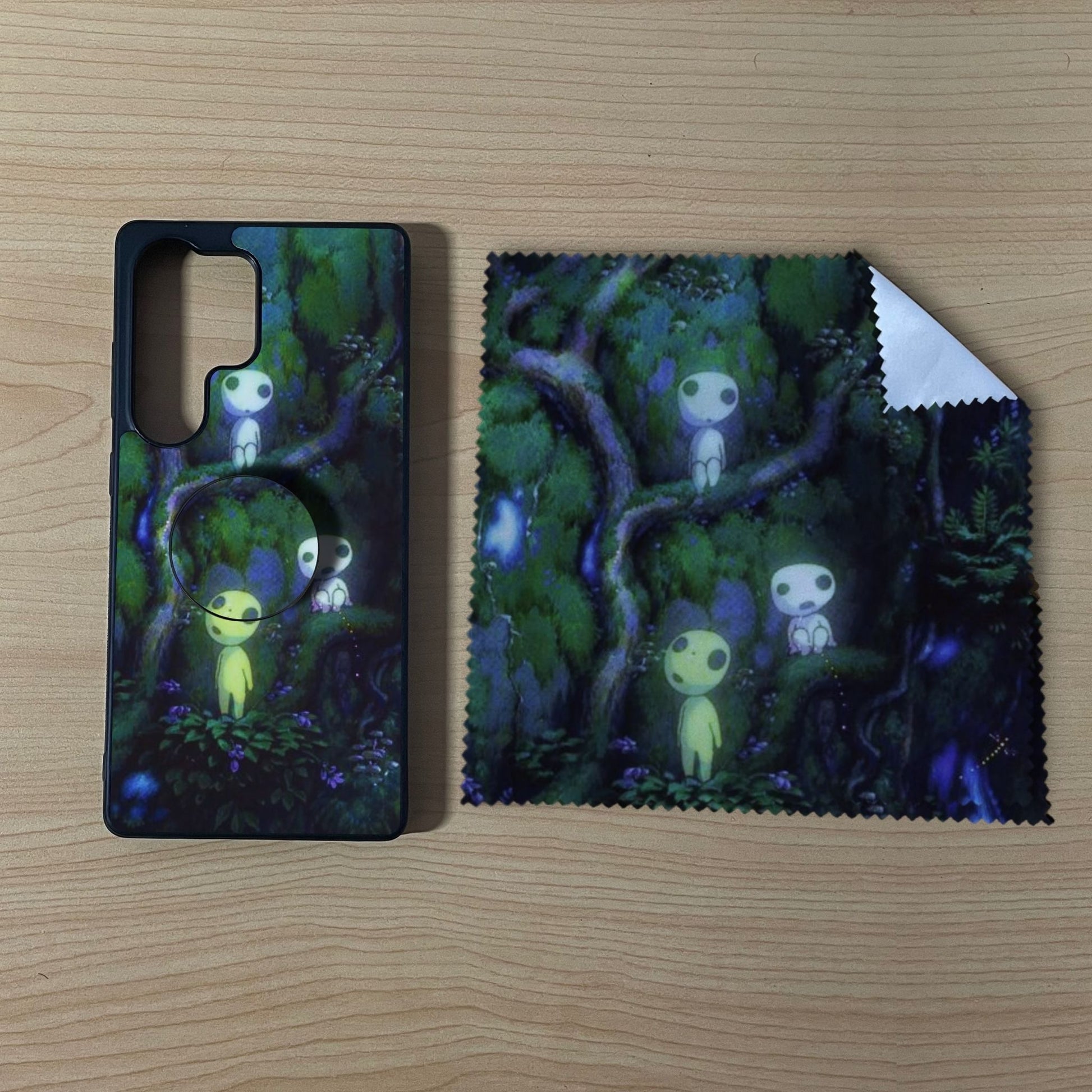 Custom Samsung case bundle set with a phone grip and cleaning cloth with matching forest design on a wooden surface.