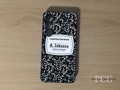Custom Samsung S24 and S24 Plus case with black and white composition book design  with "A. Johnson" written on a wooden surface