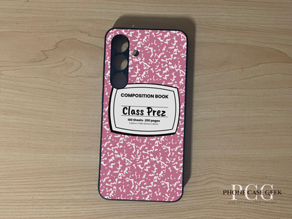 Custom Samsung S24 and S24 Plus case with pink and white composition book design  with "Class Prez" written on a wooden surface