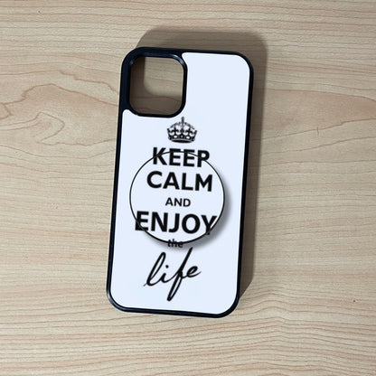 Custom iPhone case with 'Keep Calm and Enjoy the Life' text and matching adhesive phone grip on a wooden surface