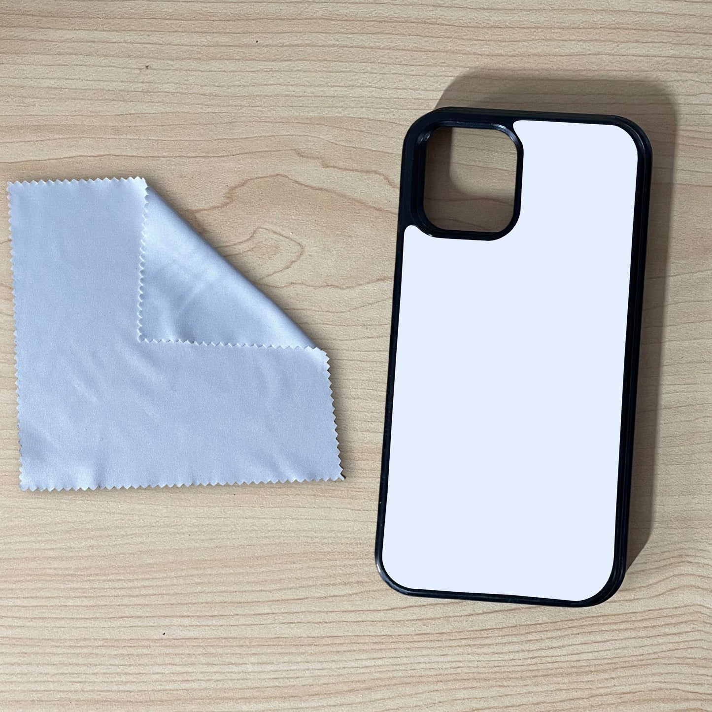 iPhone custom case and microfiber screen cleaning cloth on a wooden surface.