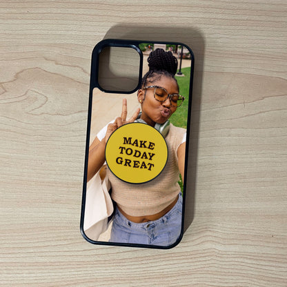 Custom iPhone case with a selfie of a woman and custom adhesive phone grip saying 'Make Today Great' on a wooden surface