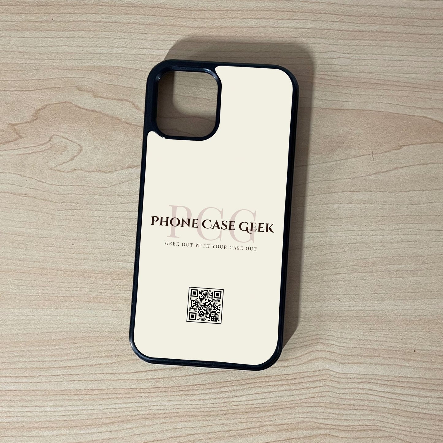 Custom phone case for the iPhone  of business branding with 'Phone Case Geek' and QR code on a wooden surface.