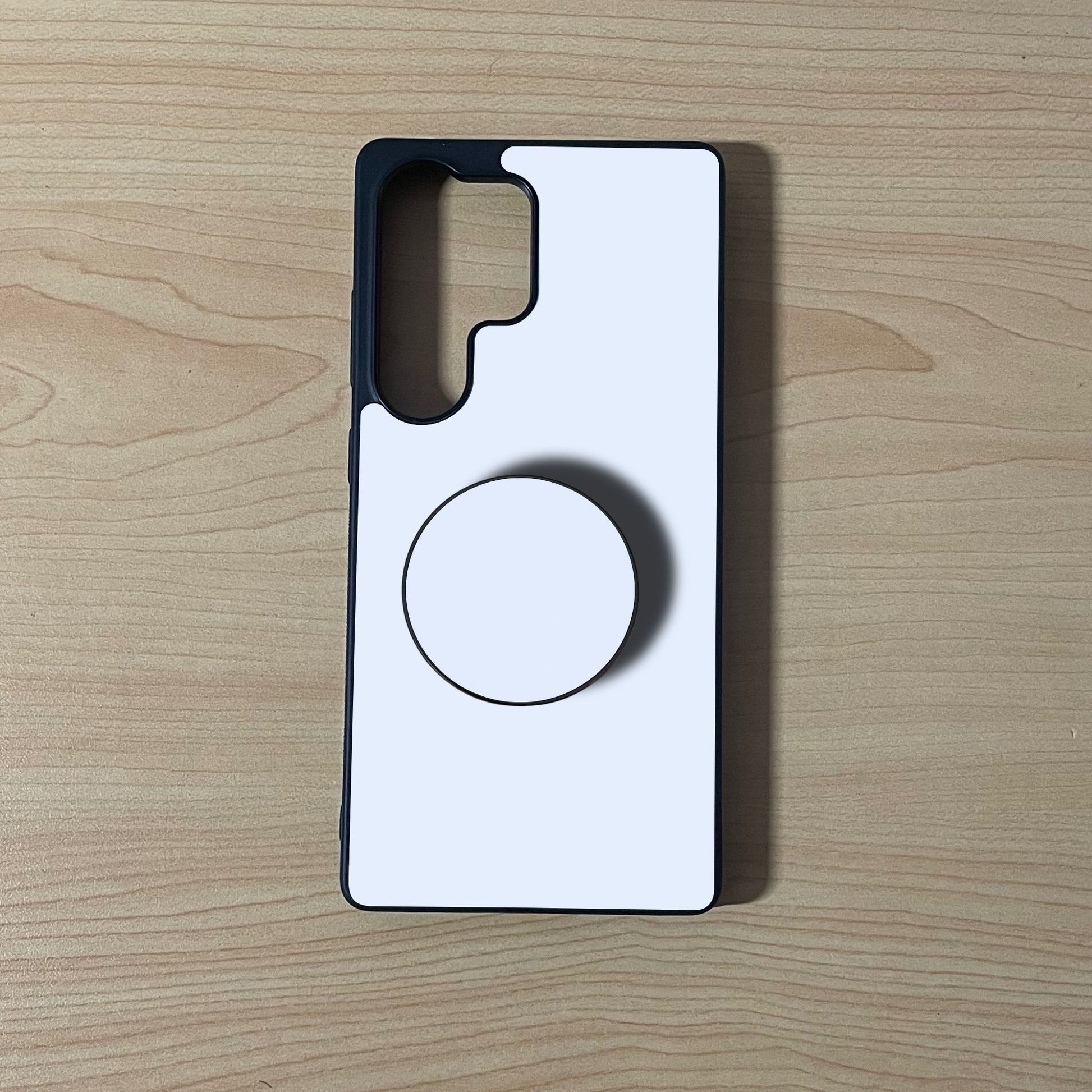 Samsung custom phone case with an adhesive phone grip attached on a wooden background.